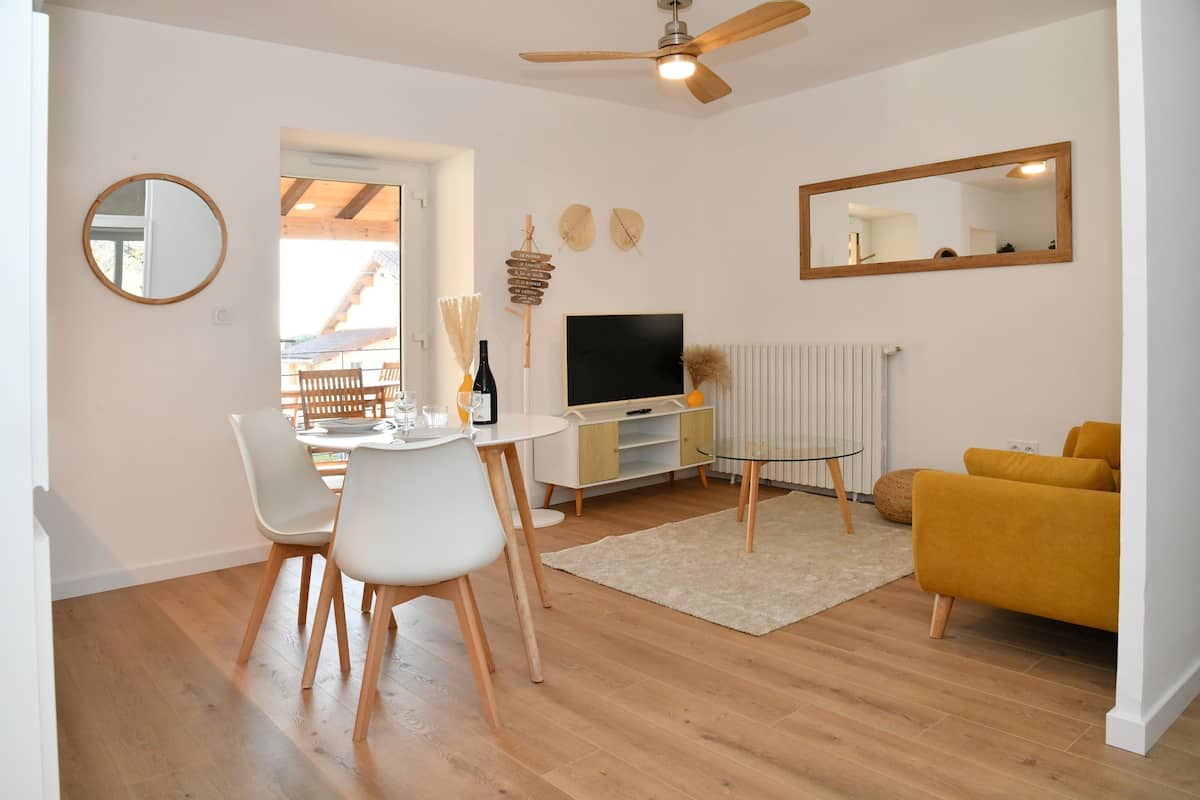 Un salon moderne comprenant un coin repas, un téléviseur et un canapé.