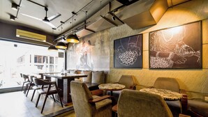 Un interior moderno con disposición de asientos, una zona de bar y obras de arte en las paredes.