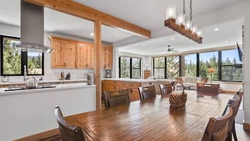 A spacious kitchen with wooden cabinets, a large island, and a dining area with a wooden table and chairs.