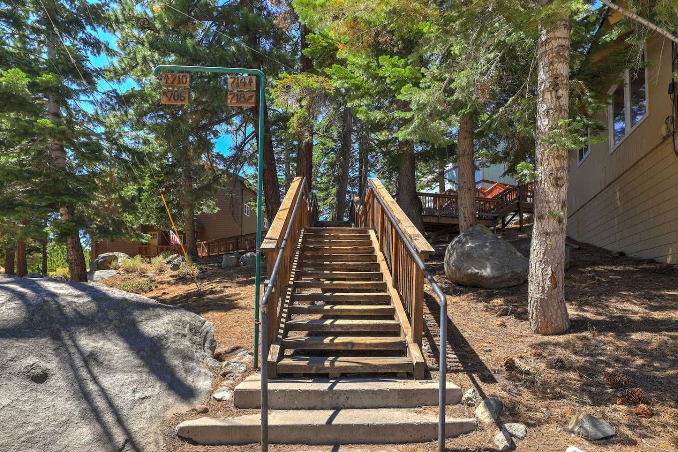 A wooden staircase leading up to a cabin surrounded by trees.