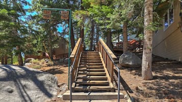 A wooden staircase leading up to a cabin surrounded by trees.