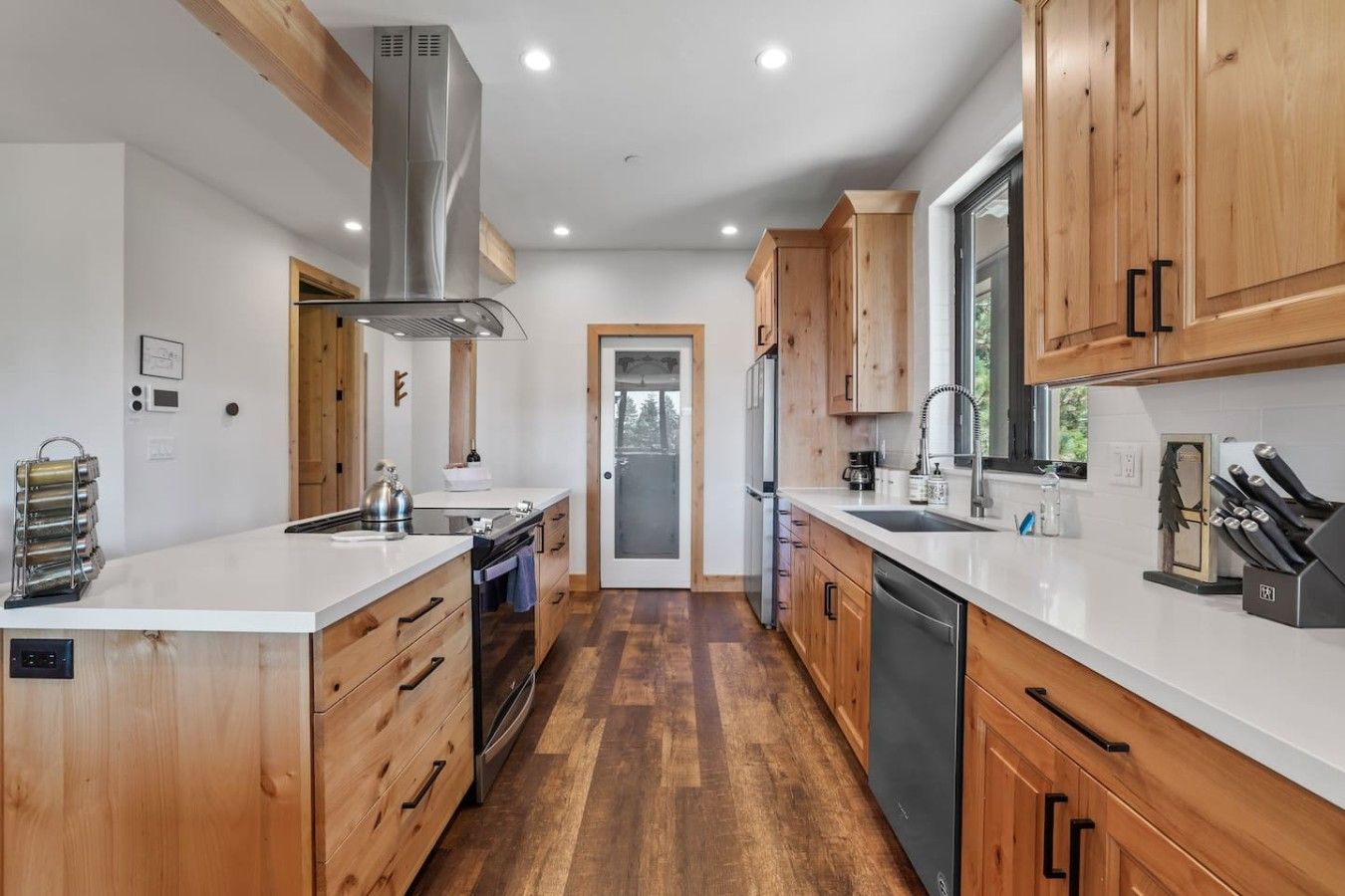 Une cuisine moderne avec des meubles en bois, des appareils en acier inoxydable et un îlot central.