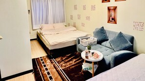 Ett rum med en säng, en soffa, ett litet bord och ett fönster med gardiner.