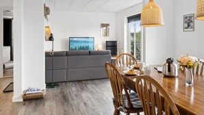 Ein stilvoller Essbereich mit Holztisch, Stühlen und Blick ins Freie durch ein großes Fenster.