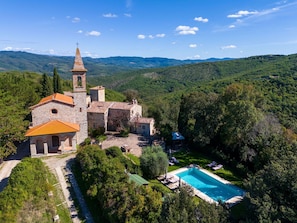 Surrounded by lush green hills, this traditional church offers a serene setting with a pool and garden.