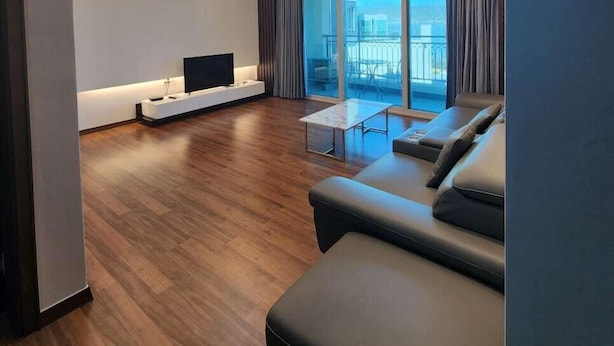 A modern living room with a sofa, a TV, and a dining area. - Kkomasi pension (Boseong)