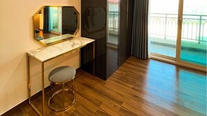 A modern hotel room with a wooden floor, a marble desk, a large mirror, and a sliding glass door leading to a balcony. - Kkomasi pension (Boseong)