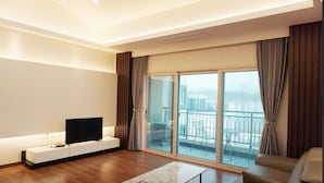 A modern living room with a flat-screen TV on a white console, a marble coffee table, and a sofa. - Kkomasi pension (Boseong)