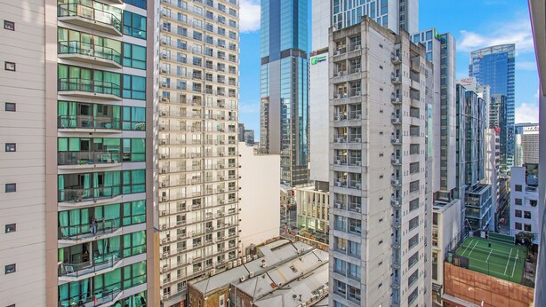 Un edificio alto con varios pisos, ventanas amplias y balcones.