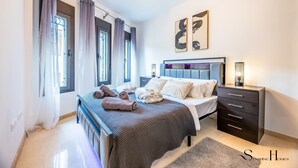 A bedroom with a bed, bedside tables, a dresser, and artwork on the wall. - Luxury townhouse with rooftop Sauna & Jacuzzi REF062 (Fuengirola)