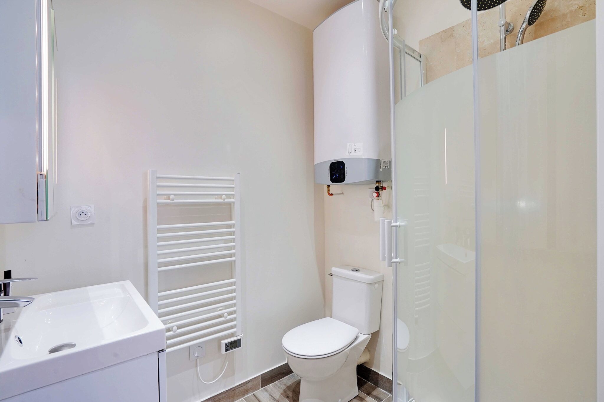 A modern bathroom with a white sink, toilet, and shower.