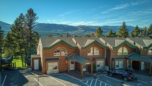 A row of wooden cabins with large windows and a parking lot in front. - Benny's Place-Marble Canyon 404P1 (Area F (Columbia Lake/Windermere Lake))