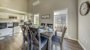 A modern kitchen with white cabinets, a microwave, and a dining area with a wooden table and chairs. - Benny's Place-Marble Canyon 404P1 (Area F (Columbia Lake/Windermere Lake))