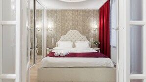 Une chambre à coucher avec un grand lit, un rideau rouge et un lustre.