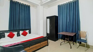 A bedroom with a bed, a desk, a chair, and a wardrobe. - Hotel B&B Heights (Guwahati)