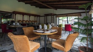 A restaurant with round tables set for dining, surrounded by velvet chairs. - PC Legacy Skardu (Skardu)