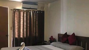 Ein Schlafzimmer mit einem Bett, Vorhängen, Kissen und einem kissenförmigen Schwan.
