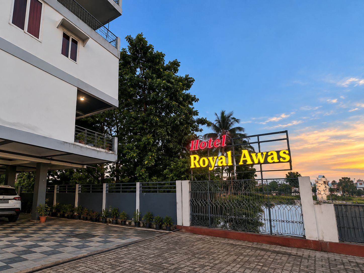 A hotel entrance with a sign reading 'Hotel Royal Awas' and a gated driveway.