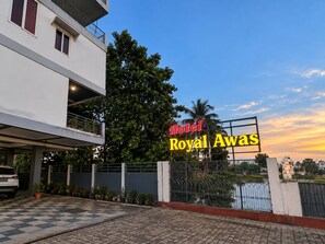 A hotel entrance with a sign reading 'Hotel Royal Awas' and a gated driveway. - Hotel Royal Awas (Biswanath)