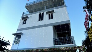 A multi-story building with a balcony on the upper level. - Hotel Royal Awas (Biswanath)