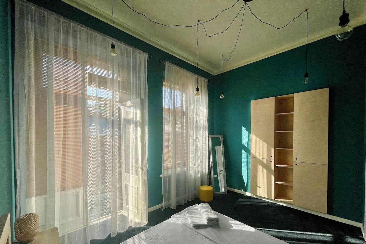 A room with a bed, a wardrobe, and a mirror.