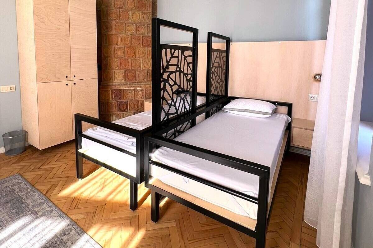 A bedroom with a bed, wardrobe, and a brick wall.