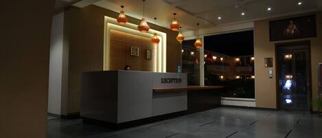A reception area with a reception desk labeled "RECEPTION," overhead pendant lighting, and a ceiling fan.