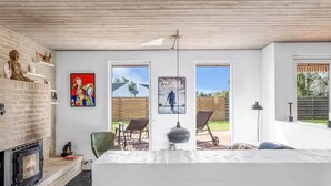 Un salon moderne doté d’une cheminée, d’une grande fenêtre et offrant une vue sur l’extérieur.