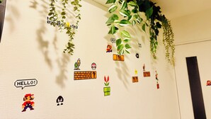 Una pared decorada con diversos diseños de arte de píxeles, incluyendo personajes y objetos de videojuegos.