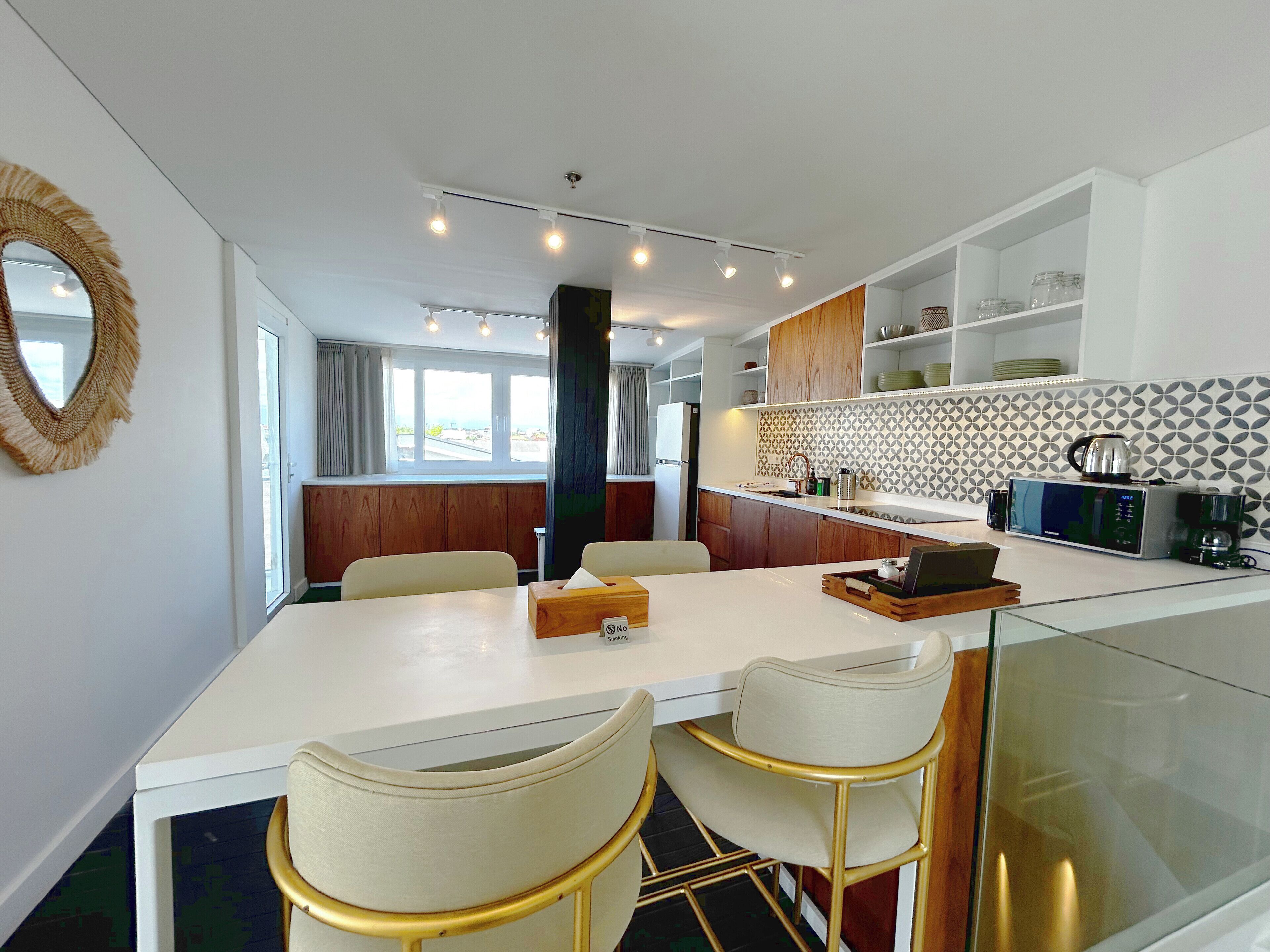 A modern kitchen with a central island, bar stools, and a dining table.