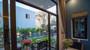 A balcony with a pool, chairs, and potted plants. - Coco Island Villa (Da Nang)