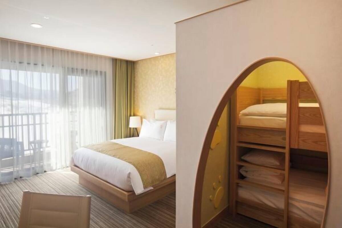 Een hotelkamer met een bed, een bureau en een raam met gordijnen.