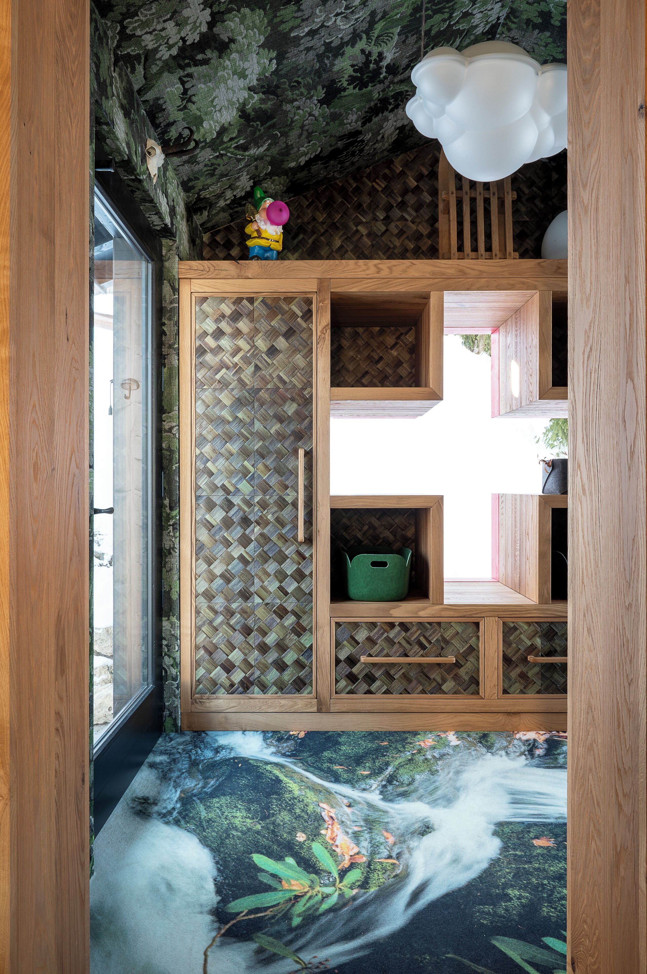 Una habitación con un aparador de madera, una lámpara colgante y un mural en la pared.