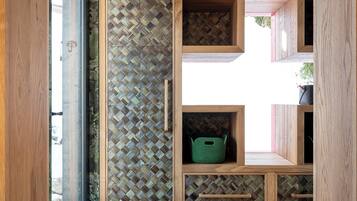 Una habitación con un aparador de madera, una lámpara colgante y un mural en la pared.