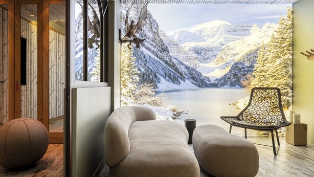 A modern interior with a large window offering a scenic mountain view, a cushioned seating area, and a decorative wall piece. - Le Hameau de Marcandou (Courchevel)