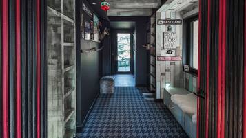 A narrow hallway with patterned flooring, a bench with a fur throw, and a door leading to a room labeled "BASE CAMP."