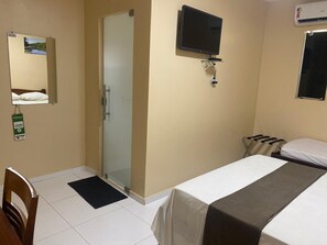 A hotel room with a bed, a television mounted on the wall, a mirror, and a window. - Belo Hotel (Tome-Acu)