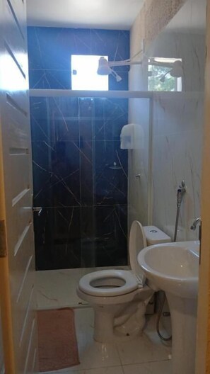 Un baño con inodoro, lavamanos y ducha.
