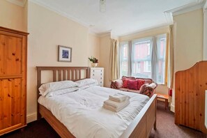 Cozy retreat with a large bed, bedside table, and comfortable chair.