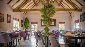 Enjoy meals in a spacious dining area with high ceilings and large windows.