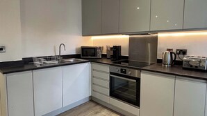 A modern kitchen with a microwave, toaster, kettle, and oven. - Solihull Studio • WiFi • NEC • BHX (Solihull)