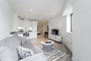 Un apartament modern amb saló, cuina i menjador.
