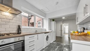 A modern kitchen with a gas stove, oven, and built-in washing machine.