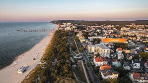 Une ville côtière dotée d’une plage, d’une jetée et d’un mélange de bâtiments résidentiels et commerciaux.