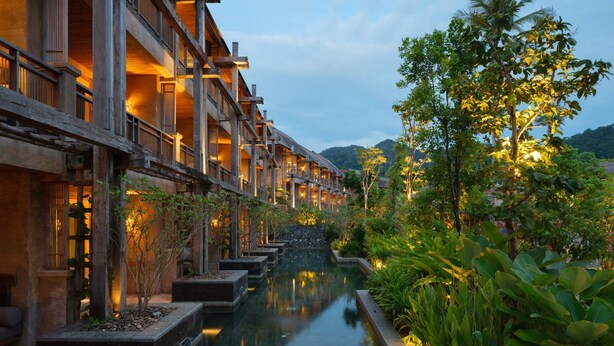 A traditional wooden building with multiple balconies, a central water feature, and lush greenery. - Dinso Resort & Villas Ko Chang, Vignette Collection by IHG (Ko Chang)