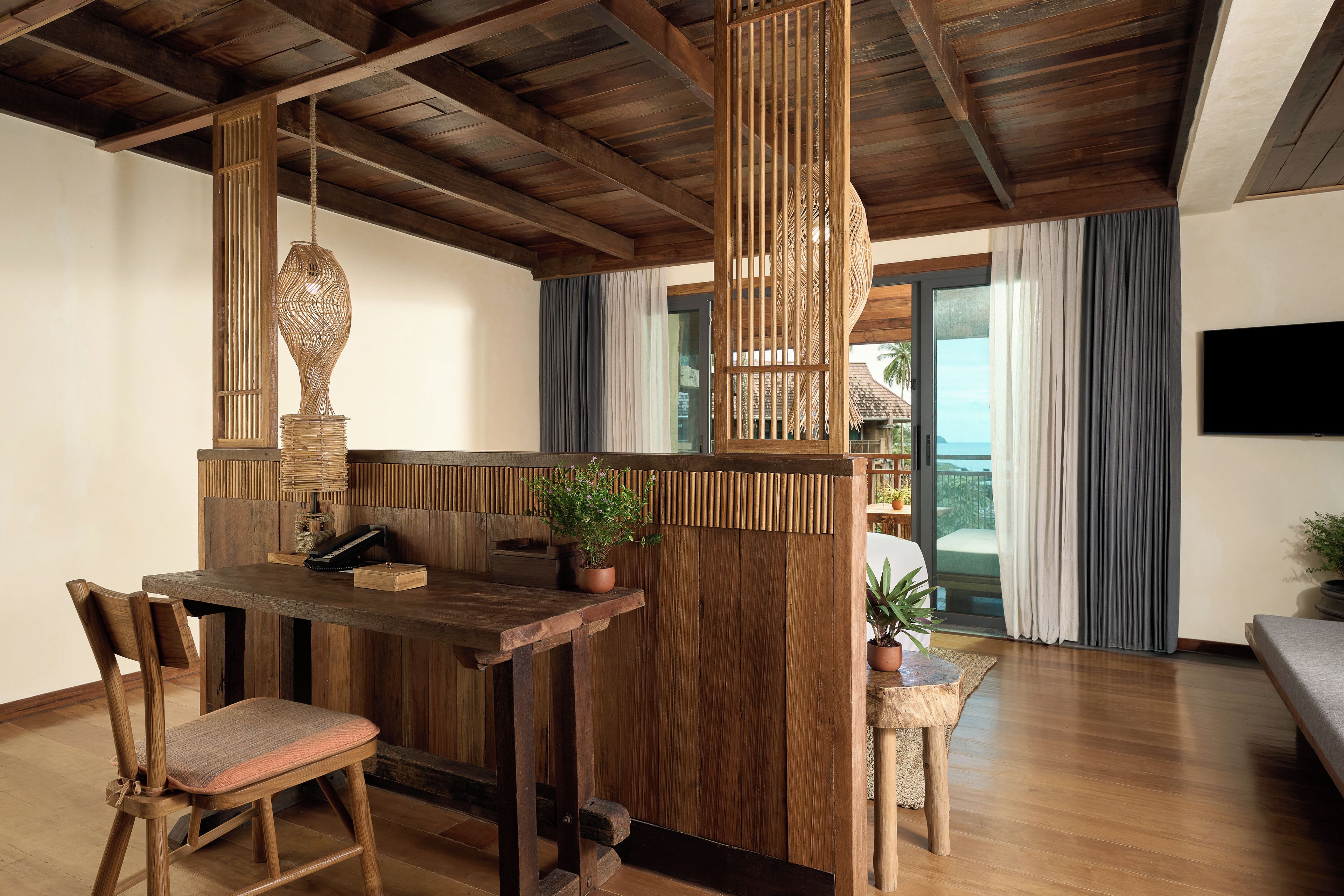 Ein Holzinterieur mit einem Essbereich, einer Bar und Blick ins Freie.