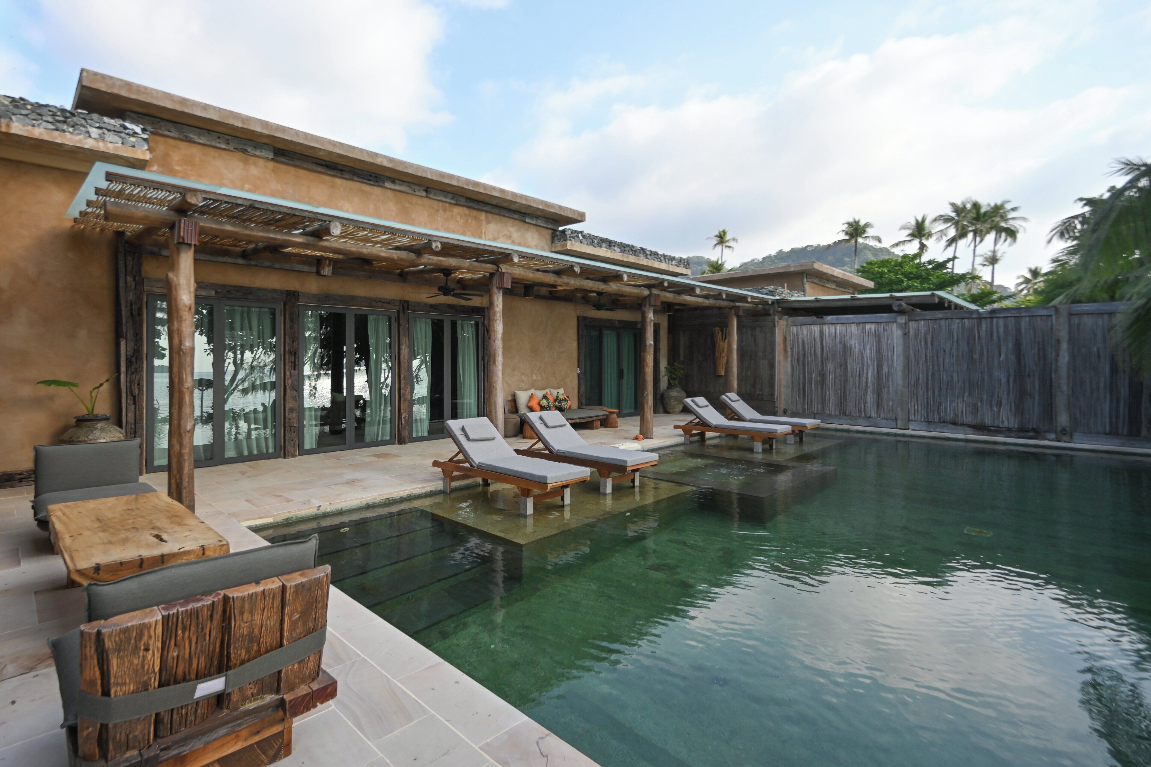 A pool area with lounge chairs and a pergola.