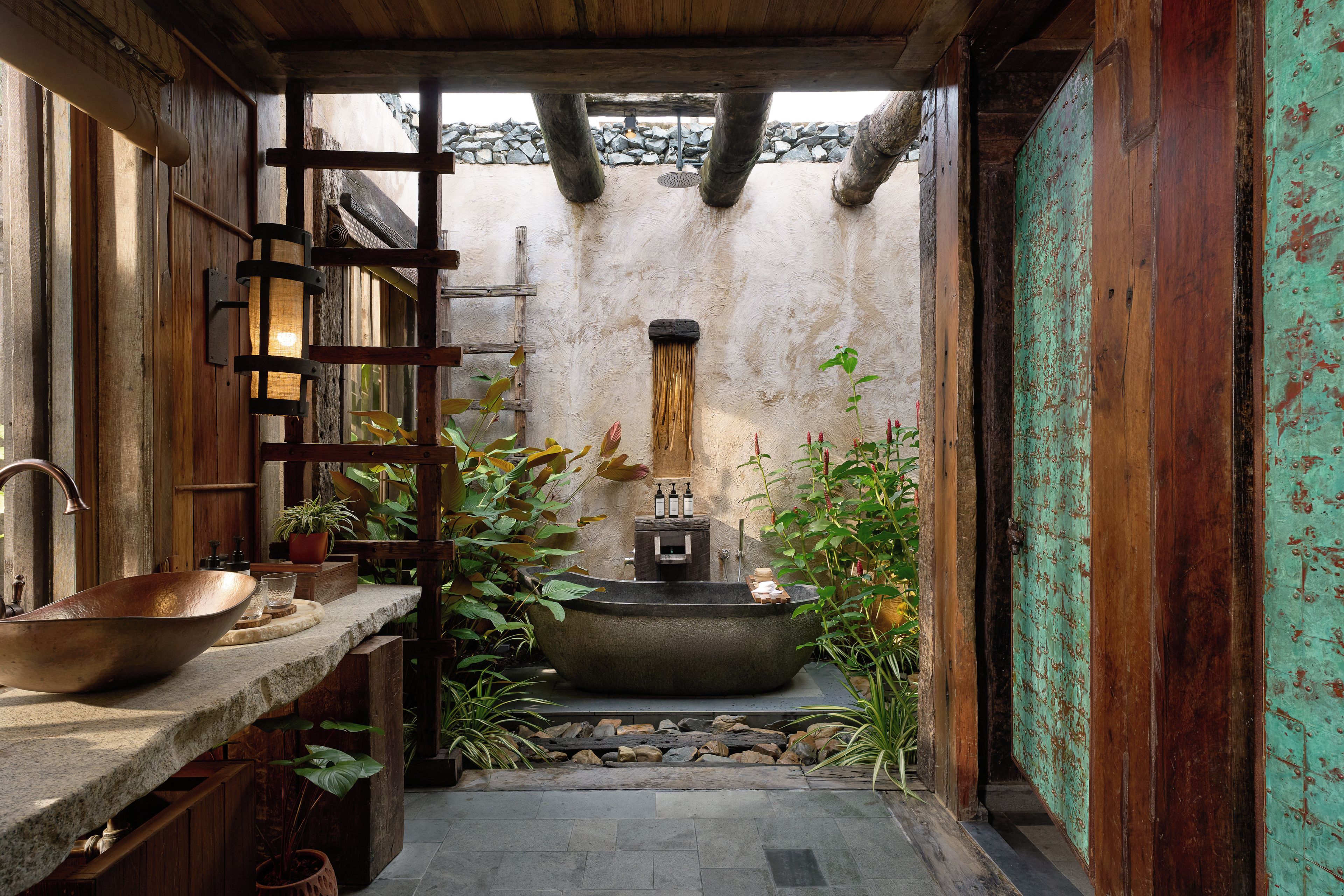 Un baño rústico con un lavabo de cobre, estantes de madera y un lavamanos de piedra.