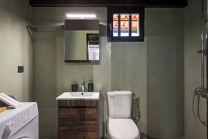 Une petite salle de bain comprenant des toilettes, un lavabo et un miroir.