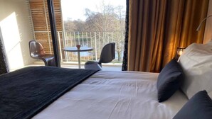 A hotel room with a bed, a small table, and a chair. - Au Bon Coin du Lac (Mimizan)